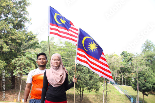 couple friends holding a malaysian flag photo