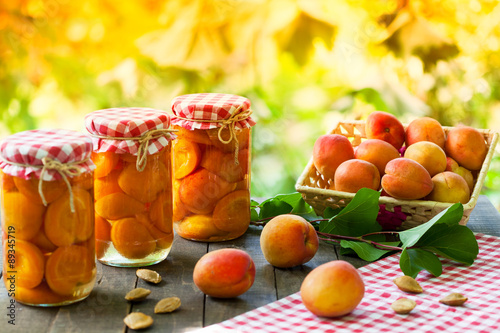 Jars with preserved apricot and fresh apricot fruit
