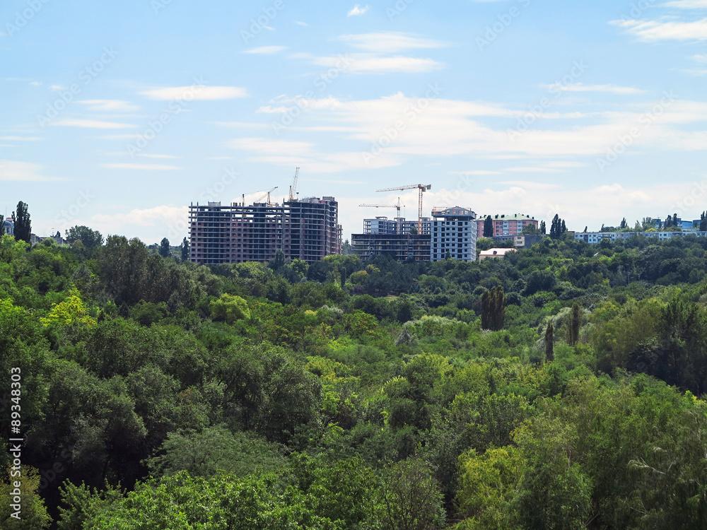 Residential modern apartment house, green forest and blue sky