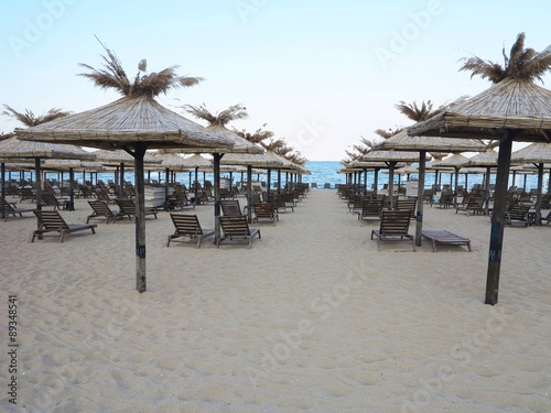 Beach chairs and umbrella on the sand near sea  blue sky