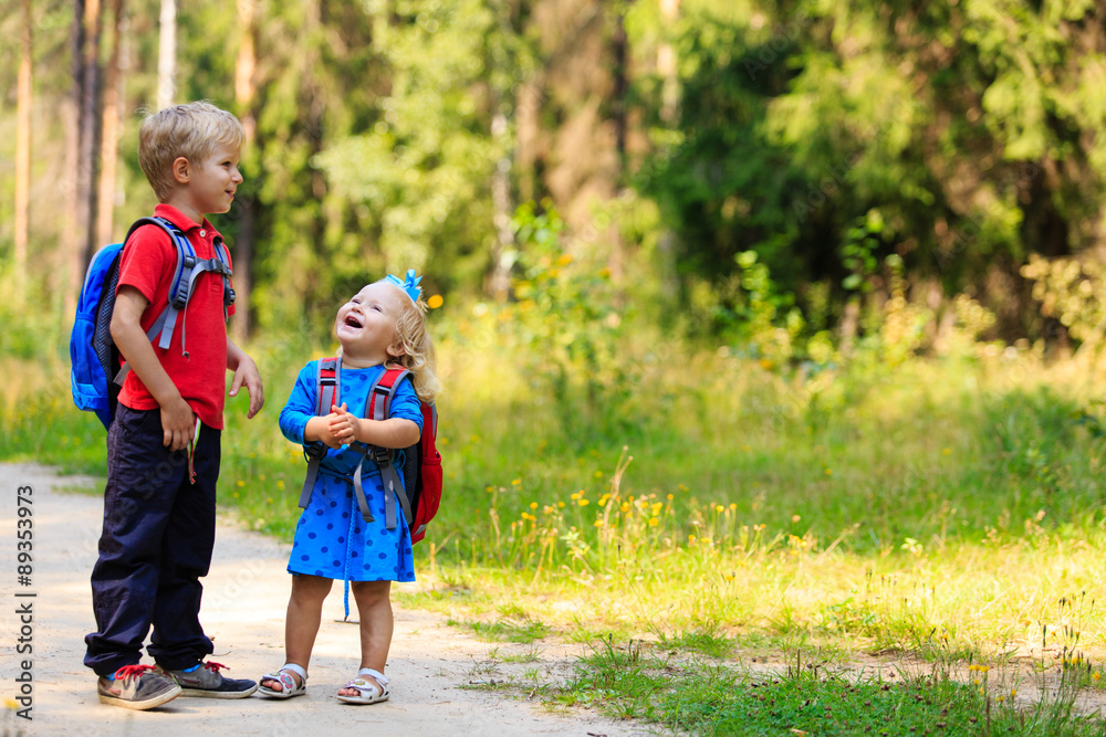 happy little boy and girl with backpacks in summer happy little boy and girl with backpacks in summer