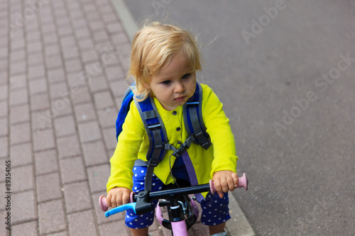 little girl riding runbike outdoors
