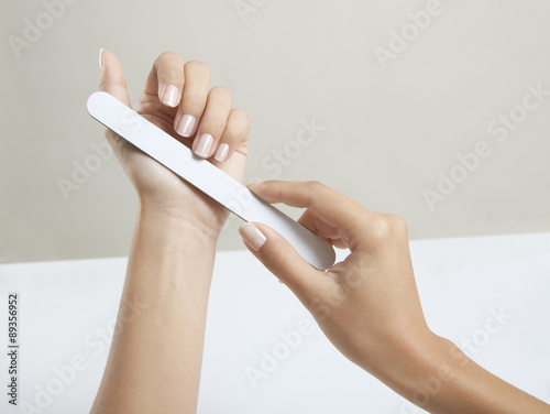 Frauenhände mit Nagelfeile photo