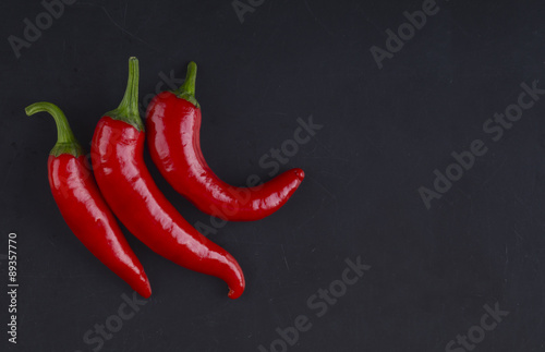 Three peppers on a black background. Three chilli peppers.