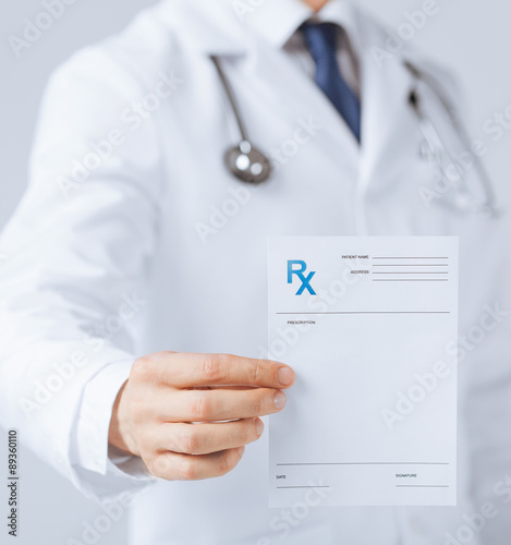 male doctor holding rx paper in hand