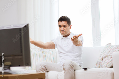 disappointed man watching tv at home