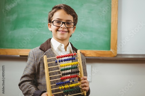 Smiling pupil dressed up as teacher holding abacus photo