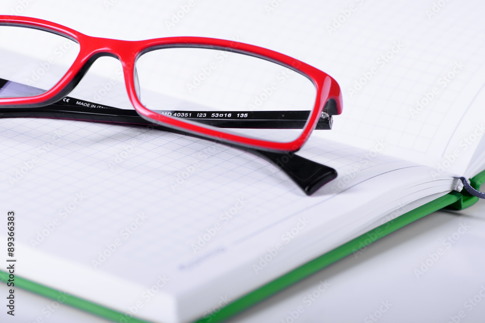 eyeglasses and paper notebook eyeglasses and paper notebook