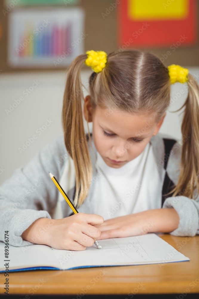 Concentrated pupil working at her desk in a classroom Concentrated pupil working at her desk in a classroom