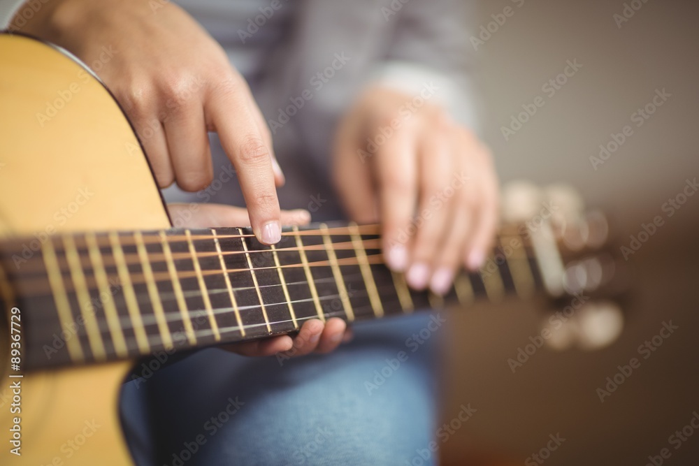 Teacher giving guitar lessons to pupil 