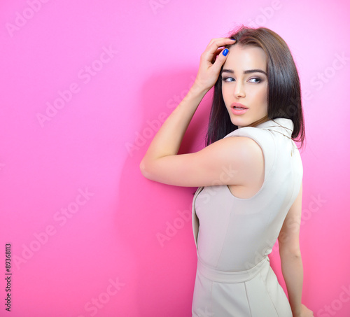 Portrait of young fashion girl over pink background