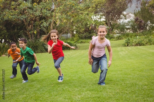 Happy kids running across the grass