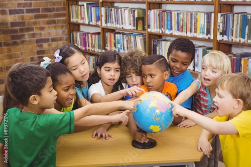 Students pointing at a globe