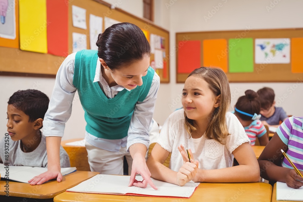 Teacher helping a little girl during class Teacher helping a little girl during class