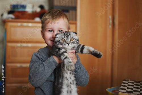 little funny boy hugs cat photo