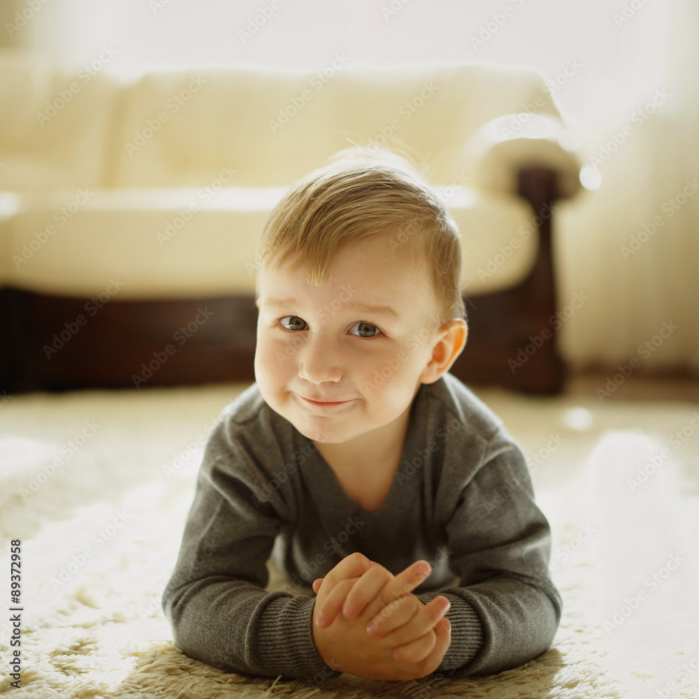 Fototapeta premium little boy lying on the carpet