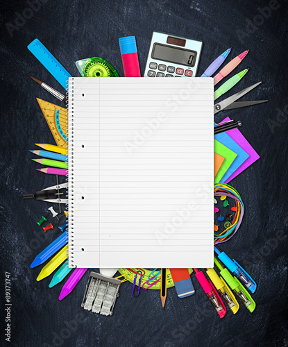 Fotografia office / school supplies under spiral-bound notebook on blackboard slate