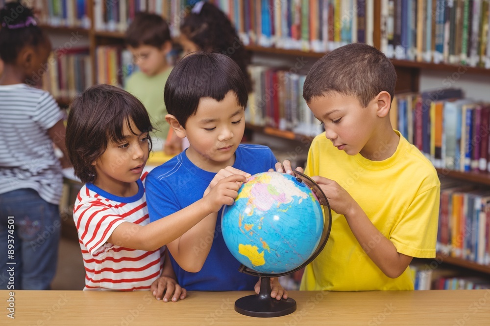Fototapeta premium Pupils in library with globe