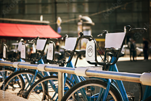standing in a number of bicycles for hire on a city street