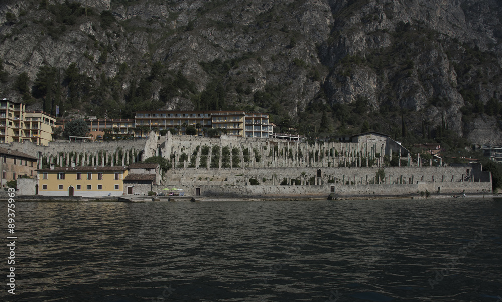 Limone sul Garda. Lake Garda. Italy, lemon house view from the lake. terraces, stone walls, stone columns, houses and wooden pergolas.