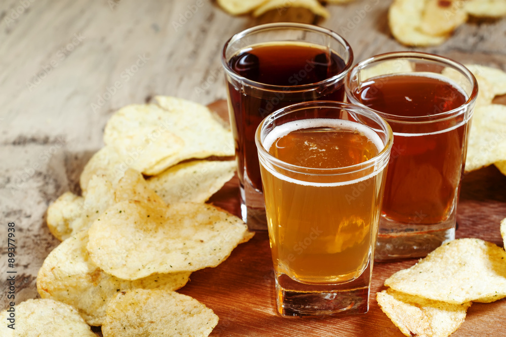 Three kinds of beer and potato chips, selective focus Three kinds of beer and potato chips, selective focus