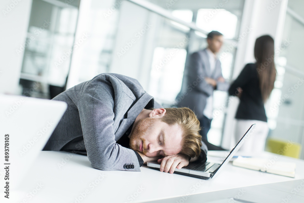 Tired young man sleeping in the office