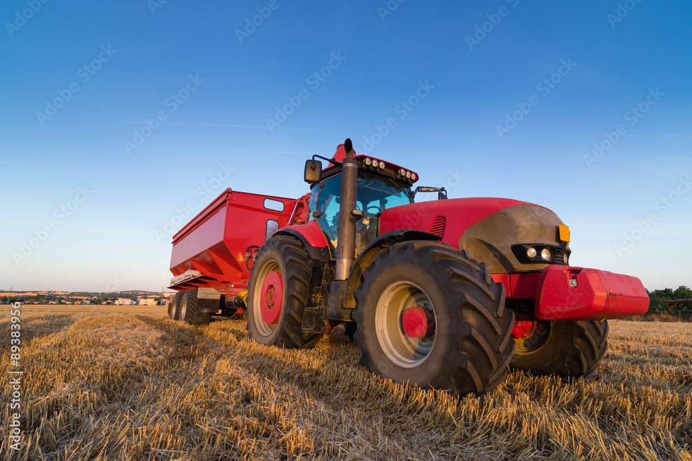 Agriculture tractor and trailer on a stubble field Agriculture tractor and trailer on a stubble field