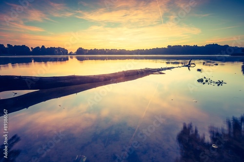 Fototapeta Naklejka Na Ścianę i Meble -  Vintage photo of beautiful sunrise over calm lake.