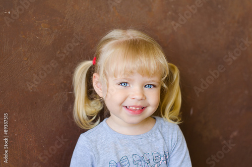 portrait of smiling little funny blonde girl