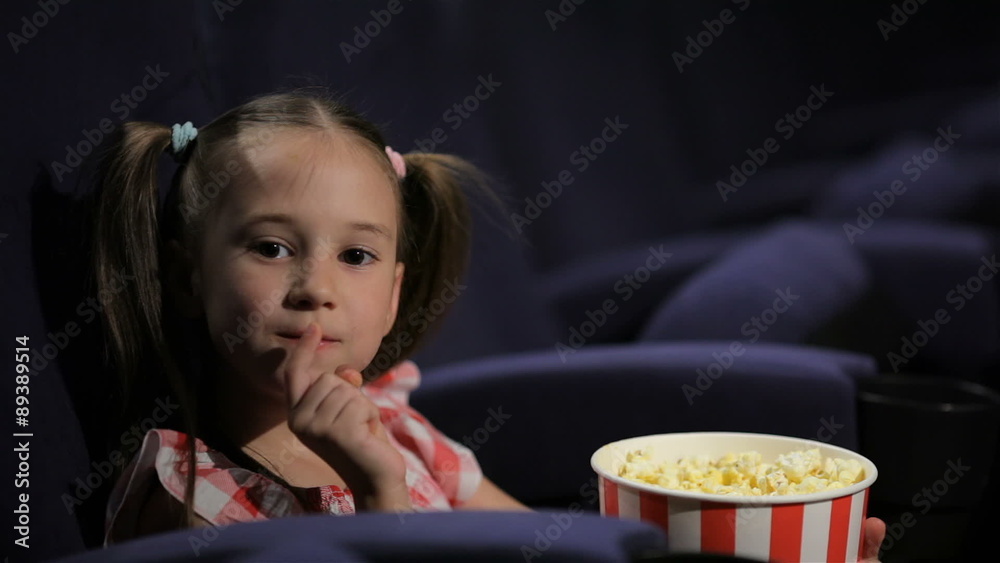 Beautiful little girl waching movie in the cinema Beautiful little girl waching movie in the cinema