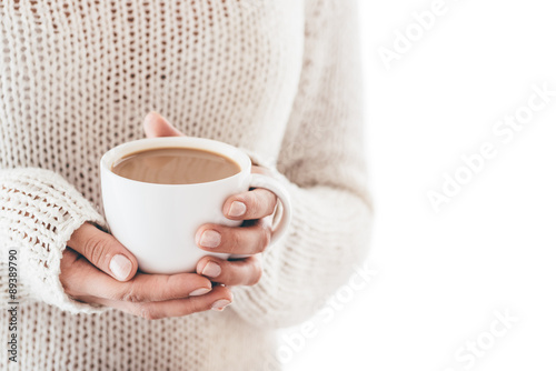 Warming cup of coffee in the hands of women isolated