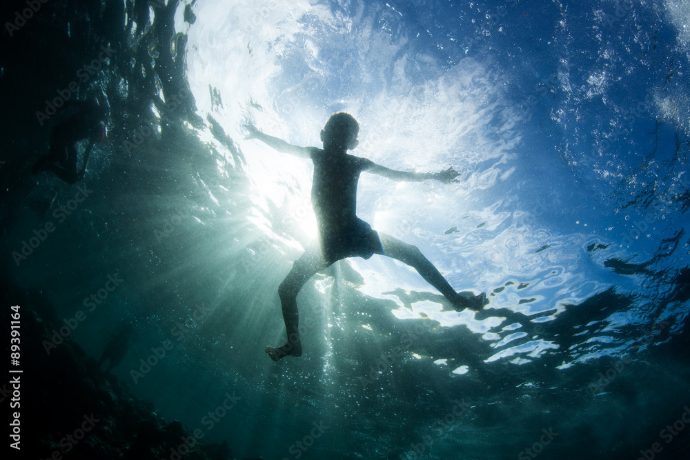 Silhouetted Child at Play in Tropical Pacific Ocean