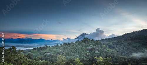 As the sun rises on Arenal Volcano and Arenal Lake, in Costa Rica, the clouds begin to gather
