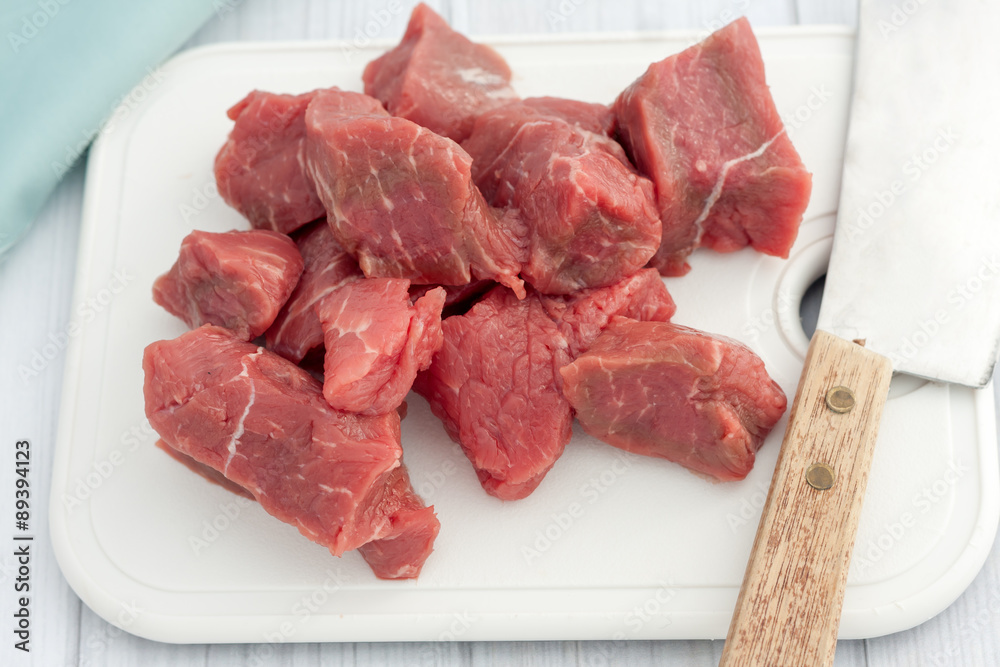 big pieces of of raw beef on white choping board big pieces of of raw beef on white choping board