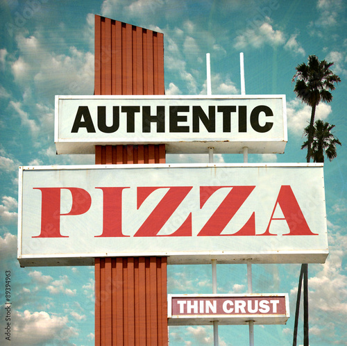 aged and worn vintage photo of authentic pizza sign with palm trees