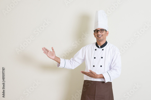 Obraz na plátně Indian male chef in uniform showing something