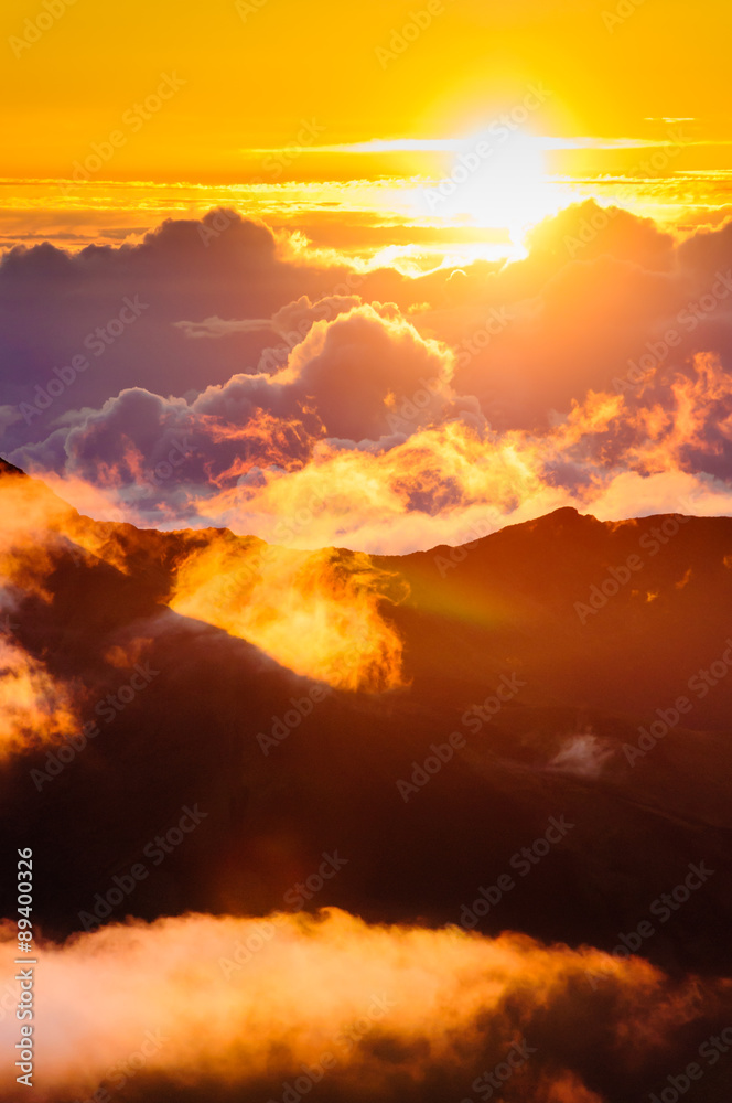 Sunrise over clouds and distant mountains from Haleakala Crater.