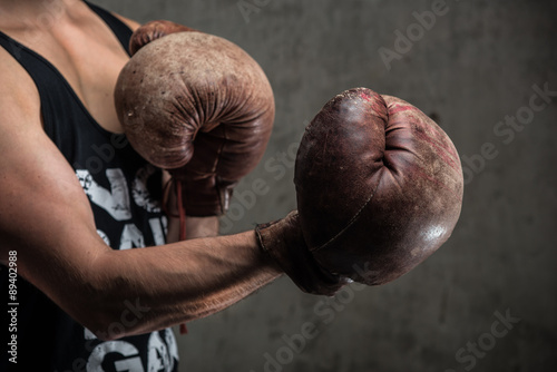 Tough caucasian male in old vintage boxing gloves, ready to fight