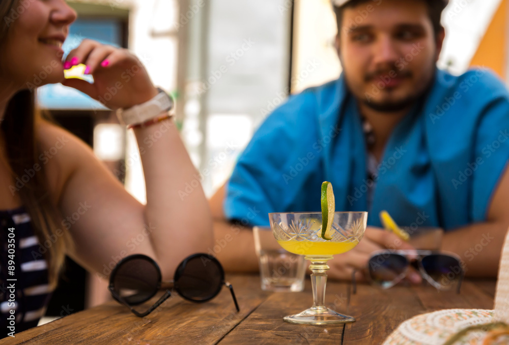 Holiday scene at cafe table Man and woman sitting at cafe table with drinks glass located wooden plank piece of lime decorated