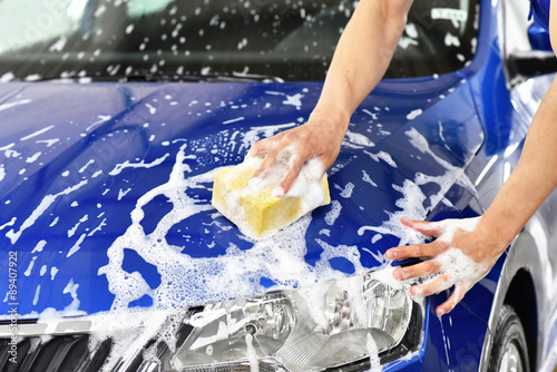 Autowäsche per Hand mit einem Schwamm, professionelle Reinigung einer Motorhaube