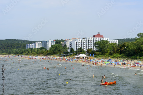 Fototapeta Naklejka Na Ścianę i Meble -  Tourists enjoy the sunny weather and relaxing on the Baltic sea beach in Miedzyzdroje, Poland.