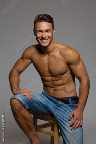 Fit Man Sitting On A Wooden Stool