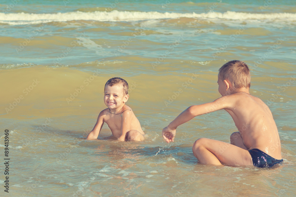 Happy  Children - two boys having fun on the beach