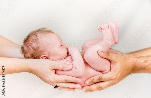 Fotografie Happy newborn Baby in hands of parents