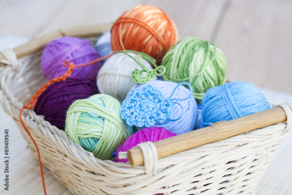 Colorful clews and crochet hook on wooden background Colorful clews and crochet hook on wooden background