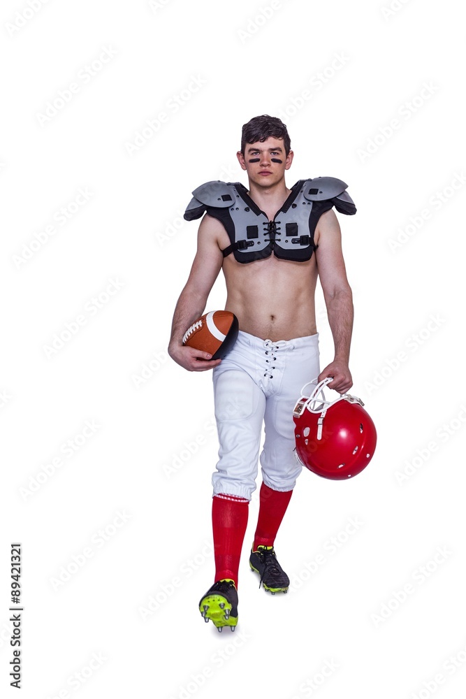 American football player walking with a ball and helmet American football player walking with a ball and helmet