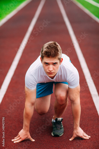 Athletic woman on track starting to run. Healthy fitness concept