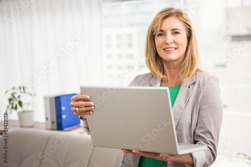 Smiling casual businesswoman with laptop © WavebreakMediaMicro