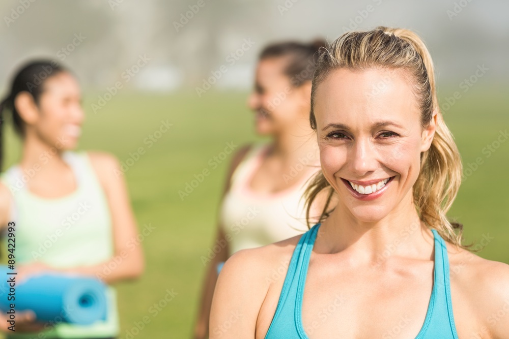 Smiling sporty blonde in front of friends Smiling sporty blonde in front of friends