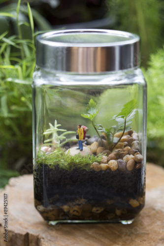 A closed terrarium decorated with a camping man.
